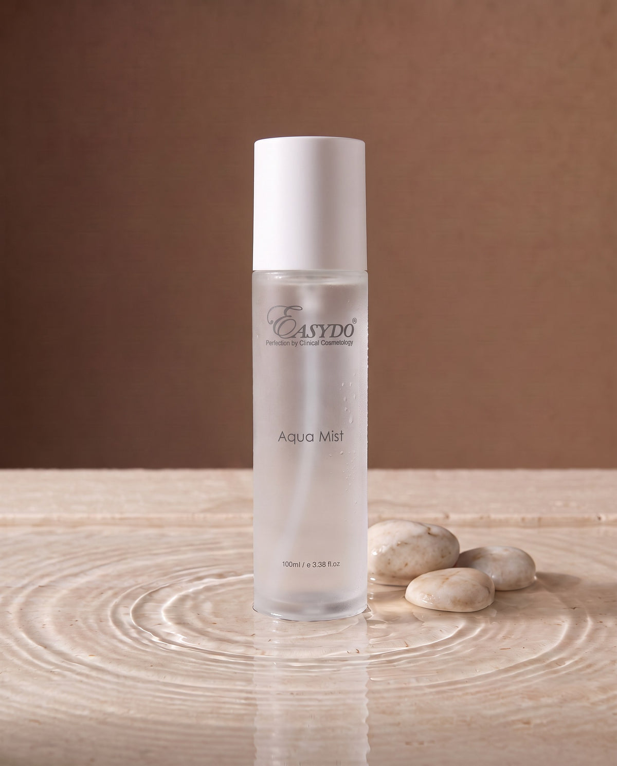 A 100ml bottle of Easydo Aqua Mist facial mist, featuring a frosted glass body and a white cap, set against a warm beige background.