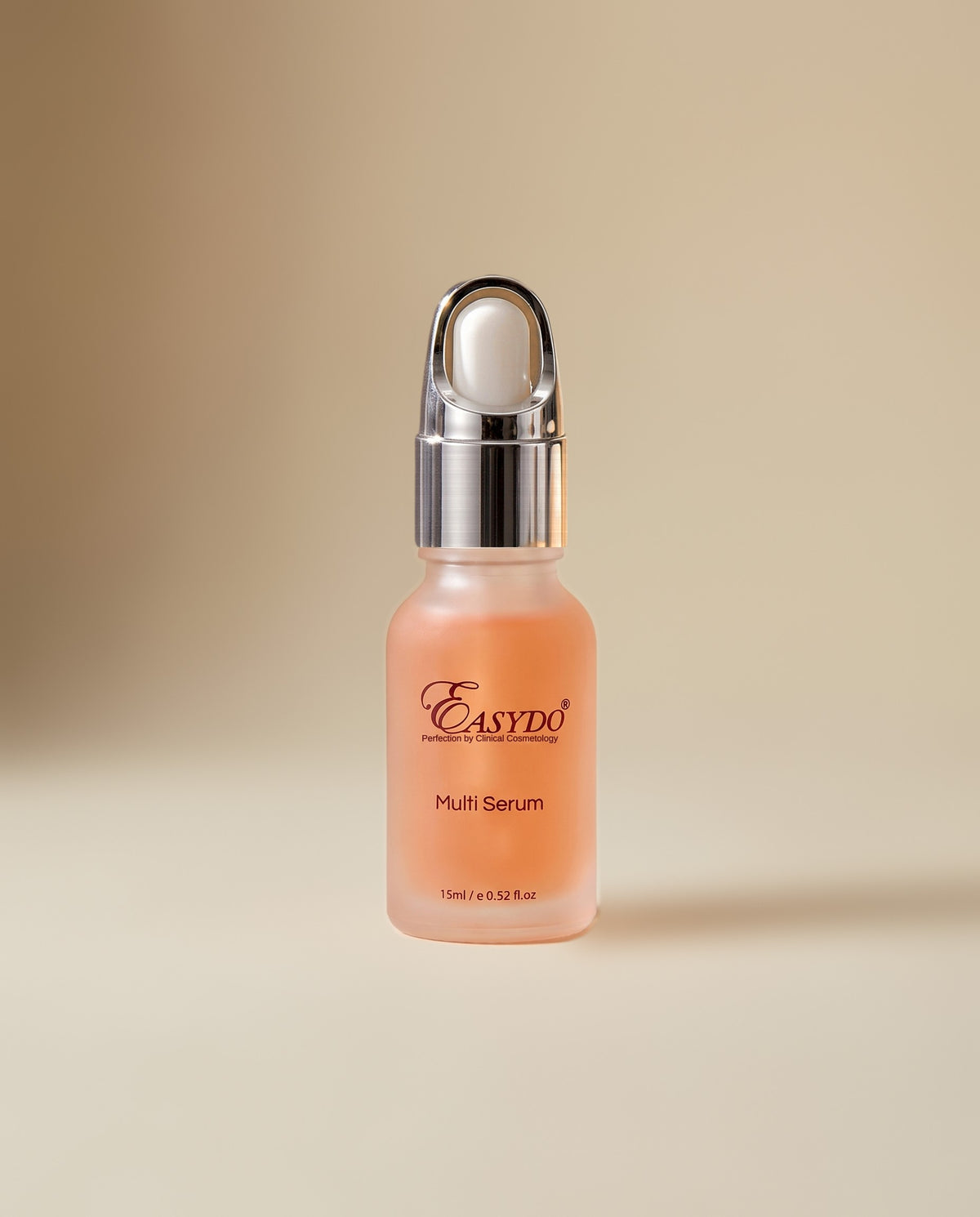 A frosted glass dropper bottle of Easydo Multi Serum with a metallic silver pump cap, filled with a peach-colored liquid, set against a warm beige gradient background.